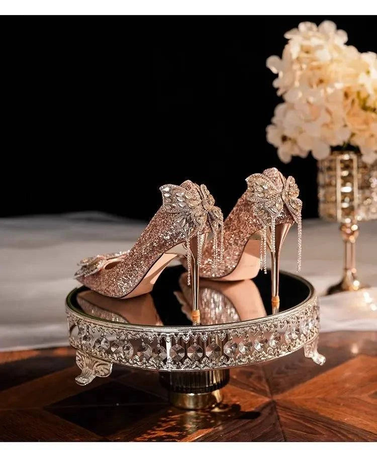 Silver high heels with a pointed toe and bow detail, featuring a shiny finish for women by LYNHURD.